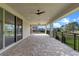 Large covered patio with brick pavers, ceiling fans, and views of the surrounding landscape at 10912 Mobberley Cir, Orlando, FL 32832