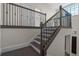 Staircase with wood steps and risers, wood handrail and black wrought iron spindles at 10912 Mobberley Cir, Orlando, FL 32832