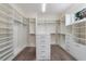 A very large walk-in closet with custom shelving and a central island with drawers at 10912 Mobberley Cir, Orlando, FL 32832