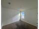A bedroom with a window, neutral walls, and neutral carpet, bathed in natural light at 1463 Riverboat Dr, Kissimmee, FL 34744