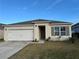 Charming single-story home featuring a two-car garage, landscaped yard, and neutral-colored exterior at 1463 Riverboat Dr, Kissimmee, FL 34744