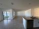 Open-concept living space with tile flooring, a granite kitchen island, and sliding doors to the backyard at 1463 Riverboat Dr, Kissimmee, FL 34744