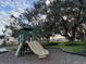 Community playground features slides, climbing structures, and mature trees for shade at 1463 Riverboat Dr, Kissimmee, FL 34744