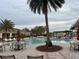 Inviting community pool area featuring a pool, palm trees, tables and lounge chairs at 1463 Riverboat Dr, Kissimmee, FL 34744