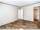 Spacious bedroom with wood-look floors, neutral walls, and doors to the closet and hallway at 1510 Oak Ln, Casselberry, FL 32707