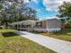 Charming single-story home showcasing a carport, landscaped front yard, and light beige vinyl siding at 1510 Oak Ln, Casselberry, FL 32707