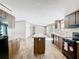 Modern kitchen featuring an island, dark cabinets, stainless steel appliances, and wood-look flooring at 1510 Oak Ln, Casselberry, FL 32707