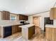 Modern kitchen featuring an island, dark cabinets, stainless steel appliances, and wood-look flooring at 1510 Oak Ln, Casselberry, FL 32707