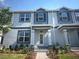 Charming two-story townhome featuring light blue siding, dark accents, and a well-maintained front yard at 15352 Burgtheater Dr, Winter Garden, FL 34787