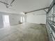 Spacious, unfinished garage with white walls and an open door to a tiled landing at 15352 Burgtheater Dr, Winter Garden, FL 34787