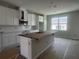 Bright kitchen featuring white cabinets, subway tile backsplash, and a central island at 15352 Burgtheater Dr, Winter Garden, FL 34787