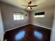 Cozy bedroom with ceiling fan, windows, and gleaming hardwood floors, creating a comfortable retreat at 1703 Doreen Ave, Ocoee, FL 34761