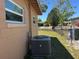 Side view of the house showcasing the fenced yard, air conditioning unit and nearby trees at 1703 Doreen Ave, Ocoee, FL 34761