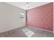 Stylish bedroom featuring a custom pink accent wall and neutral carpet at 1711 Lake Sims Pkwy, Ocoee, FL 34761
