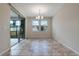 Sunlit dining room with tile floors, sliding glass doors to lanai, and modern chandelier at 1711 Lake Sims Pkwy, Ocoee, FL 34761