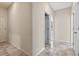 Neutral hallway featuring tile flooring and open doorways at 1711 Lake Sims Pkwy, Ocoee, FL 34761