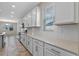 The modern kitchen features sleek white cabinets, neutral granite countertops, and stainless steel appliances at 1711 Lake Sims Pkwy, Ocoee, FL 34761