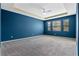 Spacious primary bedroom with tray ceiling, carpet flooring, and natural light at 1711 Lake Sims Pkwy, Ocoee, FL 34761