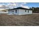 The rear of the home features a concrete patio and white trim windows at 17325 Sw 41St Cir, Ocala, FL 34473