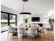 Elegant dining room with a large wooden table, modern chandelier, and an open layout connecting to the living area at 1917 Geigel Ave, Orlando, FL 32806