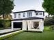 Beautiful two-story home featuring a manicured lawn, black framed windows, and a covered front porch with seating area at 1917 Geigel Ave, Orlando, FL 32806