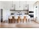 Bright, open kitchen with white cabinets, marble countertops, a large island with seating, and modern stainless steel appliances at 1917 Geigel Ave, Orlando, FL 32806