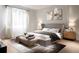 Serene bedroom with soft colors, a king-size bed, light wood floors, decorative artwork, and natural light from large windows at 1917 Geigel Ave, Orlando, FL 32806