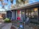 Charming home exterior with a red front door, inviting porch with seating, and manicured landscaping at 215 Nob Hill Cir, Longwood, FL 32779