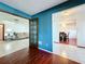 Living room featuring hardwood floors and blue accent wall with glass panel doors to the adjacent living room at 215 Nob Hill Cir, Longwood, FL 32779