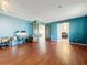 View of a spacious living room with hardwood floors, blue accent wall, and glass paneled doors to another room at 215 Nob Hill Cir, Longwood, FL 32779