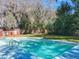 Backyard pool surrounded by a well-maintained lawn and mature trees, offering a private retreat at 215 Nob Hill Cir, Longwood, FL 32779