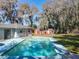 Backyard featuring a pool, storage shed, and mature trees, perfect for outdoor enjoyment at 215 Nob Hill Cir, Longwood, FL 32779
