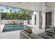 Inviting backyard with a refreshing pool, stylish lounge area, and lush landscaping with a small outdoor kitchen at 229 Alexander Pl, Winter Park, FL 32789