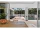 View from the dining room looking out onto the wooden deck, outdoor seating, and the pool area with mature palms at 229 Alexander Pl, Winter Park, FL 32789