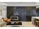Living room with a modern accent wall with a fireplace, and kitchen island with bar seating at 229 Alexander Pl, Winter Park, FL 32789