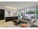 Bright living room with a kitchen view, opening onto a patio and pool area through sliding glass doors at 229 Alexander Pl, Winter Park, FL 32789
