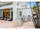 Stylish outdoor kitchen and seating area by the pool, featuring stone accents and seamless access to the home's interior at 229 Alexander Pl, Winter Park, FL 32789