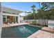Beautiful pool area with outdoor kitchen, lounge chairs, manicured landscaping, and seamless indoor-outdoor living transition at 229 Alexander Pl, Winter Park, FL 32789