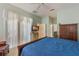 Cozy bedroom featuring ceiling fan and access to ensuite bathroom and walk-in closet at 25221 Quail Croft Pl, Leesburg, FL 34748