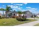 Charming home with a lush front yard, featuring mature palms and well-maintained landscaping and a paved driveway at 25221 Quail Croft Pl, Leesburg, FL 34748