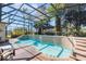 Screened-in backyard pool features tile surround, mature landscaping, and lounge seating at 25221 Quail Croft Pl, Leesburg, FL 34748
