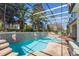Screened-in backyard pool features tile surround, mature landscaping, and lounge seating at 25221 Quail Croft Pl, Leesburg, FL 34748