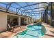 Screened-in backyard pool features tile surround, mature landscaping, and lounge seating at 25221 Quail Croft Pl, Leesburg, FL 34748