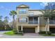 Three-story townhome with a two-car garage, mature landscaping, and a screened-in porch at 2604 Grand Central Pkwy # 12, Orlando, FL 32839