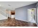 Open-concept living room with wood floors, gray accent wall, and access to outdoor screened-in patio at 2604 Grand Central Pkwy # 12, Orlando, FL 32839