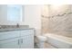 Bathroom featuring white vanity with granite countertop and tile backsplash near a toilet and tub with tiled walls at 2765 Sw 140Th Pl, Ocala, FL 34473