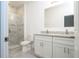 Bathroom featuring a marble-tiled shower and double granite vanity at 2765 Sw 140Th Pl, Ocala, FL 34473