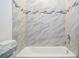 Close up of a tub with a shower, tiled walls and decorative glass accents in a full bath at 2765 Sw 140Th Pl, Ocala, FL 34473