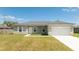 Inviting single-story home featuring a two-car garage, well-maintained lawn, and neutral color palette at 2765 Sw 140Th Pl, Ocala, FL 34473