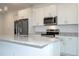 Close-up of a kitchen island featuring a stainless steel faucet, granite countertops, and white cabinetry at 2765 Sw 140Th Pl, Ocala, FL 34473